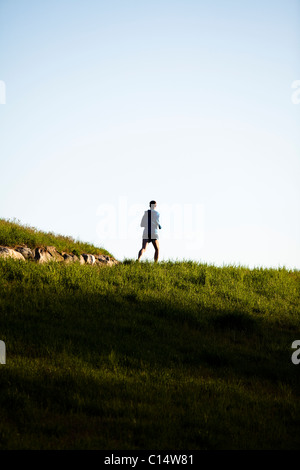 Ein Mann trägt eine blaue Jacke läuft auf einem Wanderweg im Rockefeller State Park in Sleepy Hollow, New York. Stockfoto