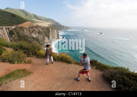 Paar fotografieren auf Weg mit Blick auf die felsige Klippen/Küste von Big Sur, Kalifornien. Stockfoto