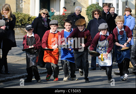 Olney Pancake Race jungen Wettbewerb in dieser jährlichen Veranstaltung in Olney Buckinghamshire England 2011 Stockfoto