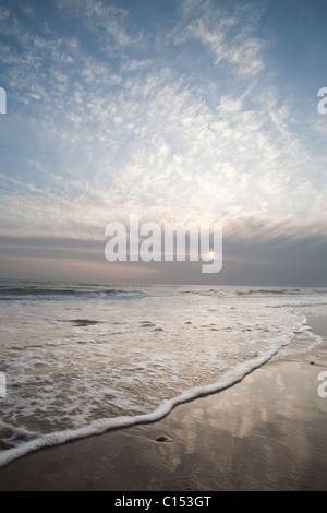 Sonnenuntergang und Wellen am Strand in Nord-Wales Stockfoto