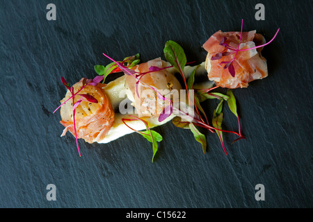 Starter-Pfanne gebratenen Jakobsmuscheln und Parma-Schinken serviert auf einem Bett aus Blumenkohl-Püree mit Mikro Salat garnieren 116365 Food gekrönt König Stockfoto