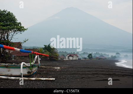 Balinesische traditionelle Fischerboote, genannt Jukung, hochgezogen am Strand von Amed, Bali, unterhalb des Vulkans Gunung Agung. Stockfoto