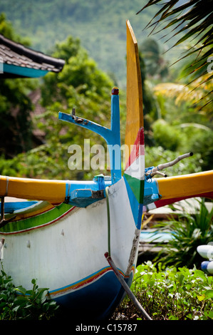 Eine traditionelle balinesische Outrigger Segeln Fischerboot, genannt eine Jukung hochgezogen am Strand in Amed, Bali, Indonesien. Stockfoto