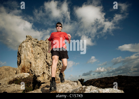 Mann läuft über felsiges Gelände im Naturpark des Cap de Creus, Katalonien, Spanien Stockfoto