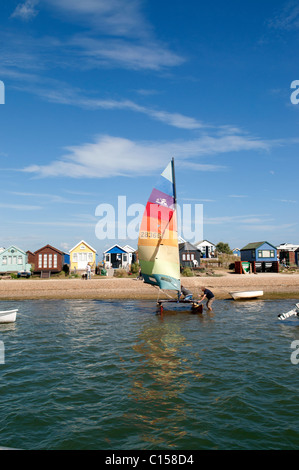 Kleinen Katamaran Segelboot hinausgedrängt wird ins Wasser bei Hengistbury Head in der Nähe von Christchurch in Dorset, England Stockfoto