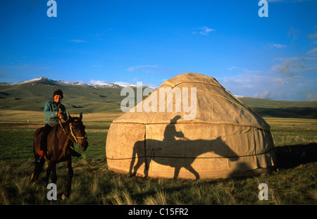 Pferd und Reiter vor einer Jurte, Verein‑ zu Mountain Range, Song-Kul, Kirgisien, Zentralasien Stockfoto