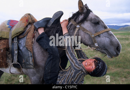 Nomad junge spielt mit seinem Pferd, Song-Kul, Kirgisien, Zentralasien Stockfoto