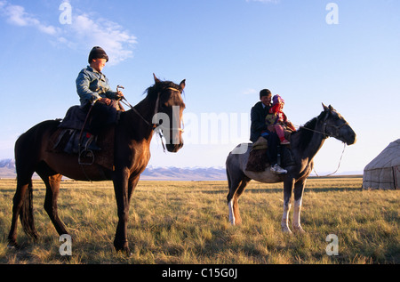 Nomadenkinder auf ihren Pferden reiten Reiten, Song-Kul, Kirgisien, Zentralasien Stockfoto