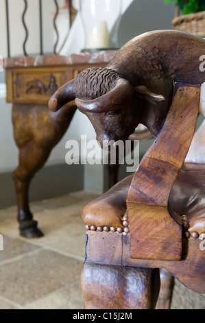 Geschnitzte Stierkopf auf Holzstuhl Stockfoto
