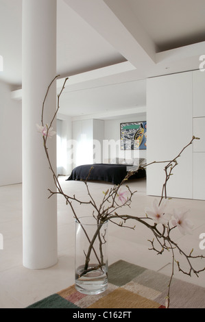 Magnolia Zweig in einem Glas im Schlafzimmer der minimale weiße Lager Konvertierung Stockfoto
