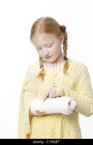 Mädchen, 8 Jahre alt, mit geflochtenen Haaren und einem gebrochenen Arm in Gips Stockfoto