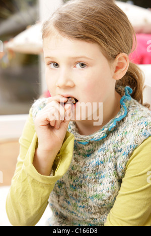 Ein acht-Jahr-alten Mädchen Schokolade mit einem schlechten Gewissen zu essen Stockfoto