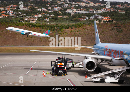 Eine erste Wahl-Flugzeug startet, während ein Flugzeug für die Beförderung im internationalen Flughafen von Funchal, Madeira bereitet Thomson. Stockfoto