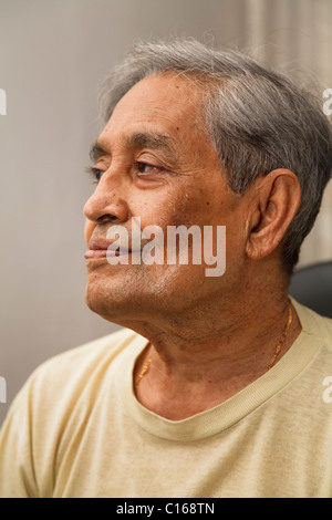 Porträt des alten indischen asiatischen Mann sitzt in Freizeitkleidung Stockfoto