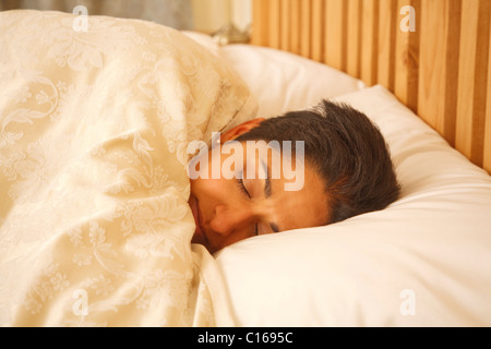 Indische Asiatin in einem luxuriösen Bett schlafen Stockfoto