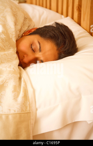 Eine junge indische Frau suchen schlafend im Bett sehr gemütlich Stockfoto