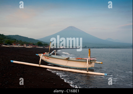 Balinesische traditionelle Fischerboote, genannt Jukung, hochgezogen am Strand von Amed, Bali, unterhalb des Vulkans Gunung Agung. Stockfoto