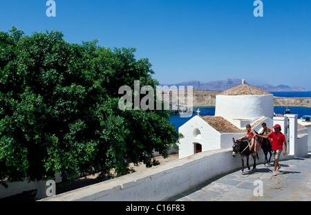 Kinder reiten Esel vor einer Kapelle, Lindos, Rhodos, Dodekanes, Griechenland, Europa Stockfoto