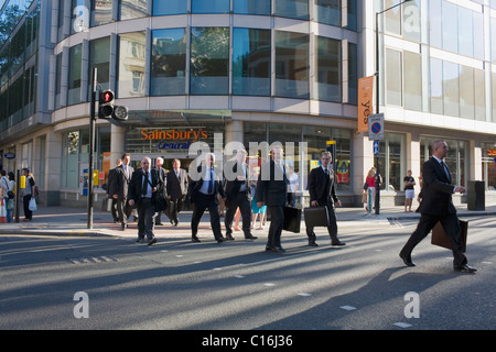 Geschäftsleute mit Aktentaschen überqueren Sie die Straße im Zentrum von London. Stockfoto