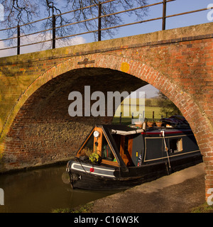 Barge/Schmalschiff und alte Backsteinbrücke auf der Leicester Line des Grand Union Canal in der Nähe des Foxton Locks Market Harborough, Leicestershire. Stockfoto