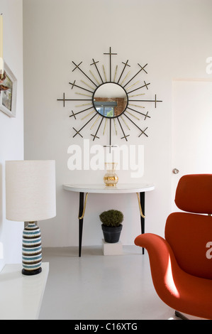 Sunburst, Spieglein an der Wand der Retro-Stil Wohnraum mit roten Pierre Paulin Tulip Lounge Stuhl Stockfoto