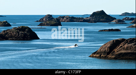 Lofoten-Inseln, weit oben im Norden in der norwegischen Arktis. Kleine Boot Wettrennen zwischen den riesigen Felsen entlang der Küste Stockfoto