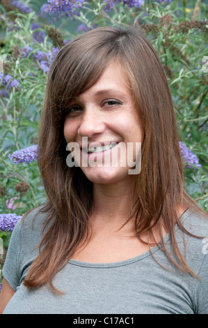 Kate Burns; Schöne junge Dame im Freien durch Schmetterlingsstrauch; Model Release 20100719KB 19820629 Stockfoto