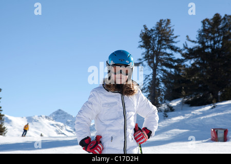 Junge Skifahrer auf der Piste lächelnd zu Kamera tragen Schutzhelm und Maske Stockfoto