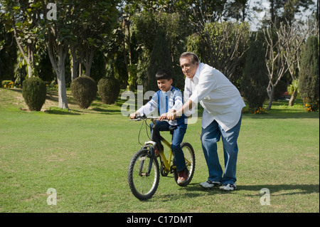 Man lehrt seine Enkel wie Fahrrad fahren Stockfoto