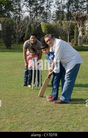 Familie spielen Cricket in Rasen Stockfoto