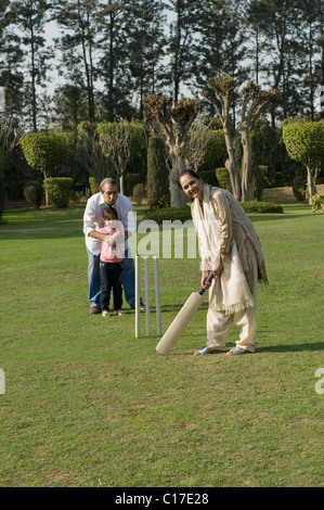 Familie spielen Cricket in Rasen Stockfoto