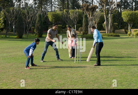 Familie spielen Cricket in Rasen Stockfoto