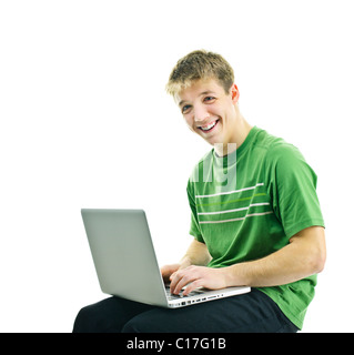 Lächelnde junge Mann, sitzend mit Laptop-Computer isoliert auf weißem Hintergrund Stockfoto