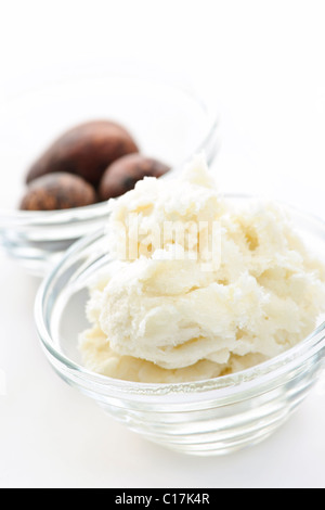 Shea-Butter und Nüssen in Glasschalen isoliert auf weiss Stockfoto