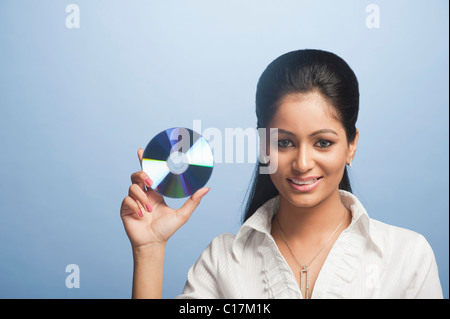 Porträt einer Geschäftsfrau zeigt eine DVD und lächelnd Stockfoto