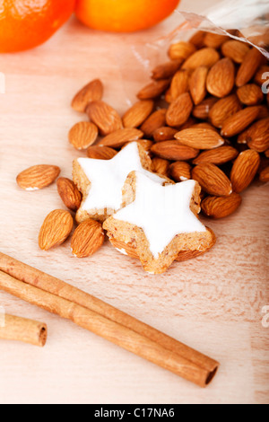 Zimt Kekse mit Mandeln, Mandarinen und Zimt-sticks auf einem Holztisch Stockfoto