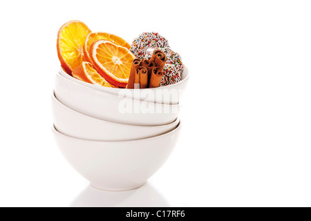 Getrocknete wo Scheiben mit Cinnammon Stöcken und Schokolade Ringe in Haufen von weißen Schalen Stockfoto