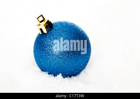 Blaue Christbaumkugel im Schnee Stockfoto