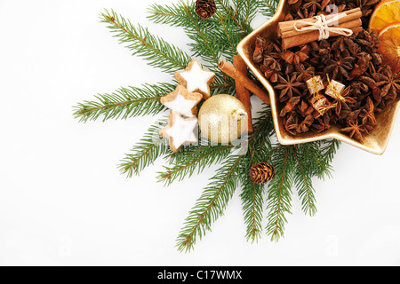 Zweige der Tanne mit einem Weihnachtsbaum-Kugel, Zimtsterne und einen Weihnachtsteller mit getrockneten Orangenscheiben, Sternanis Stockfoto