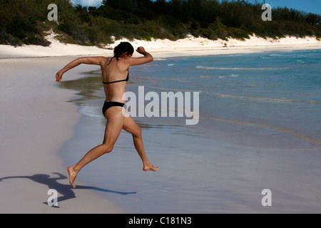 Frau springt auf einen Strand, Horseshoe Bay, Bermuda Stockfoto