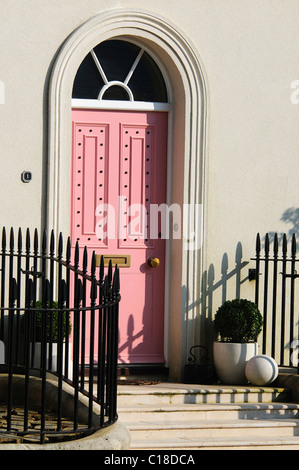 Eine rosa Haustür mit Stufen am Verkehrssysteme Village, Dorchester, Dorset, UK. März 2011 Stockfoto