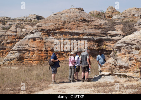 Trekking durch Isalo Nationalpark, Madagaskar, vor dem Hintergrund der Jurassic Sandstein Touristen erodierten Klippen. Stockfoto