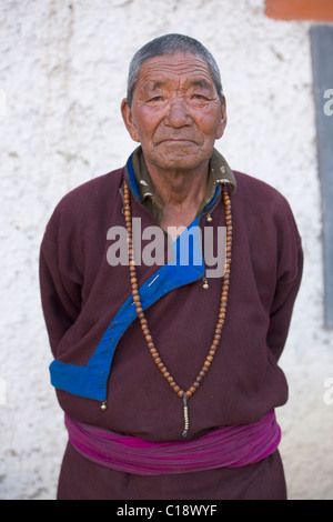 Ladakhi Greis in traditioneller Tracht mit Gebetskette im Gästehaus (Ladakh) Jammu & Kaschmir, Indien Stockfoto