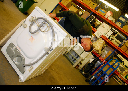 Mann Reparatur Recycling-Waschmaschine für Wiederverkauf, Clacton, Essex, England. Stockfoto