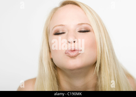 Junge blonde Frau spitzte ihre Lippen Stockfoto