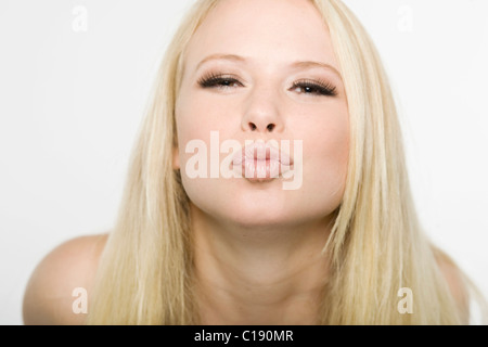 Junge blonde Frau spitzte ihre Lippen Stockfoto