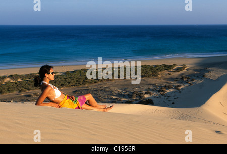 Frau liegt auf einer Düne mit Blick auf die Playas de Sotavento Strand, Fuerteventura, Kanarische Inseln, Spanien, Europa Stockfoto