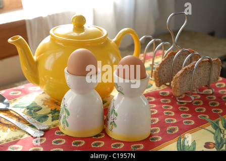 Englisches Frühstück gekochte Eier in Eierbecher, Toast im Rack, Tee. Stockfoto