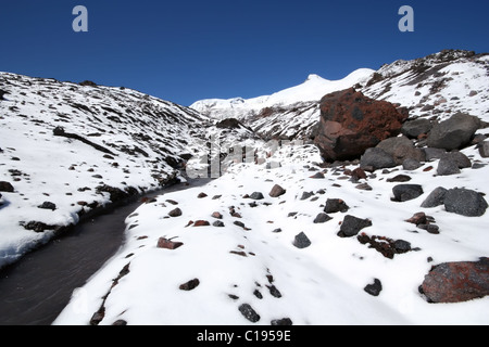 Gletscherfluss unter Steinen und Schnee Felsen im Kaukasus, Elbrus Bereich, Kabardino-Balkarien. Stockfoto