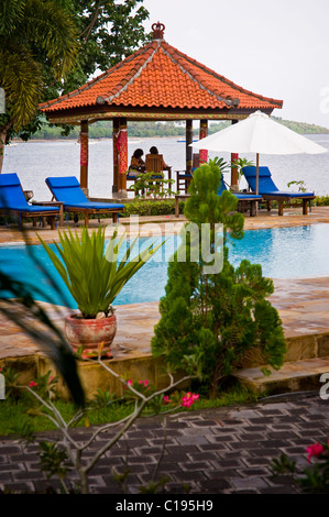 Ein paar in Bali genießt eine romantische Mittagessen am Strand unter einem Ballen in das Resort Dorf Pemuteran an der Westküste. Stockfoto